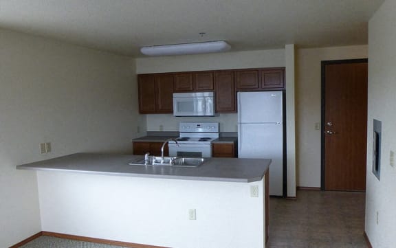 Image of stove, microwave, sick, refrigerator, cabinets, and counter space