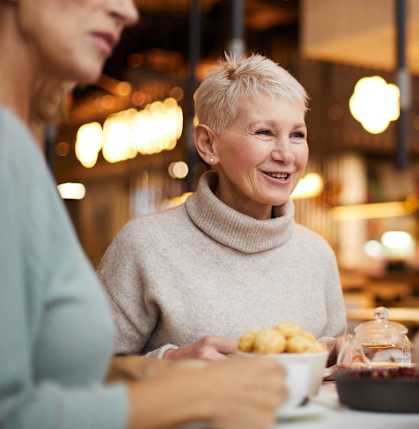 A group of people having a conversation over a meal in a restaurant.