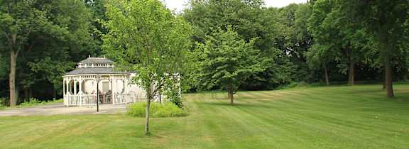 A green lawn with a pavilion in the background.