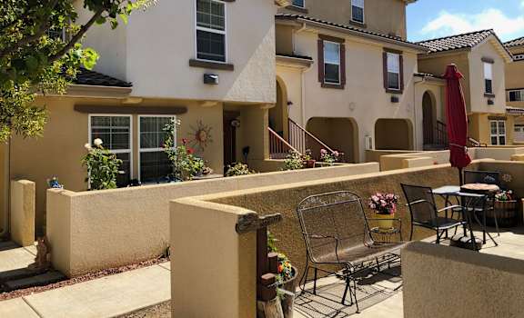 Outside unit patio area showing flowers, plants and lawn furniture.