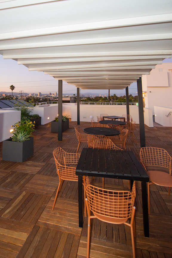 A patio with a table and chairs under a roof.