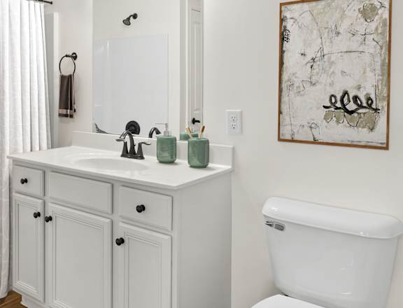 a white bathroom with a shower sink and toilet