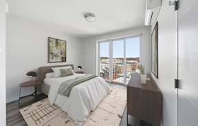 A bedroom with a large bed and a view of the outside.