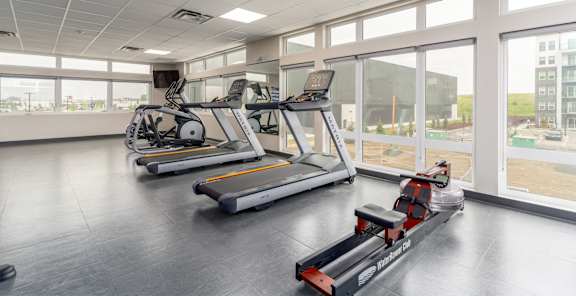 A gym with treadmills and exercise bikes. at G17 Apartments at Tamarack, Edmonton
