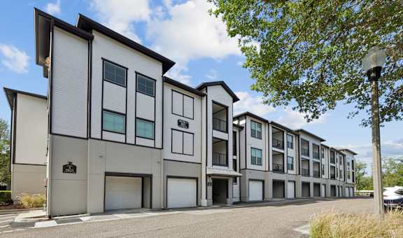 A modern apartment building with a parking lot in front.