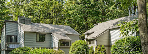 A house with a grey roof and a green lawn in front.