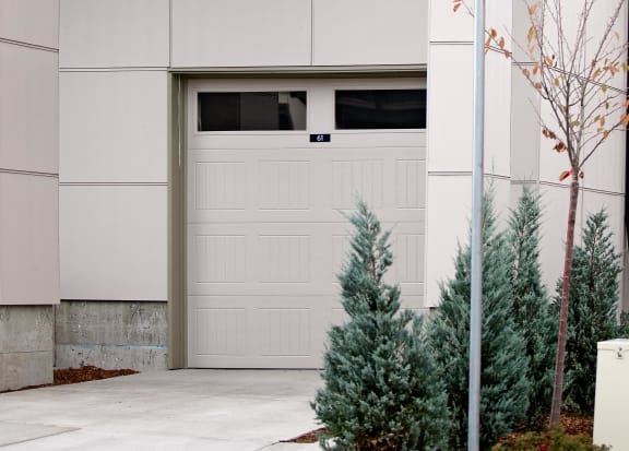 a house with a garage and trees in front of it