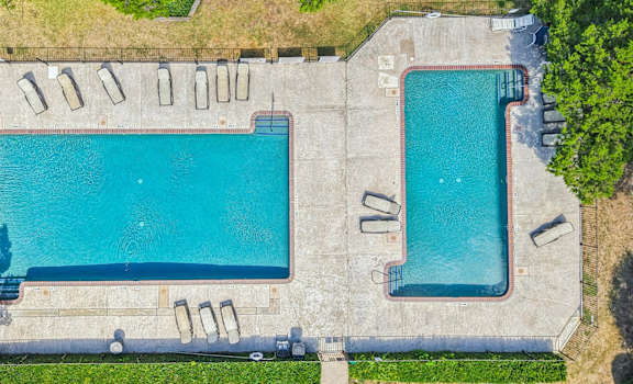An aerial view of a swimming pool surrounded by trees.