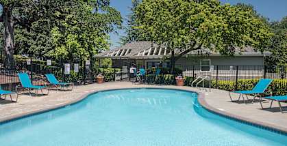 Rocklin Gold apartments swimming pool and lounge chairs and clubhouse building in the background 