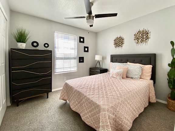 Model Bedroom with Wood Bed Frame and White Bedding Next to Wood Nightstand