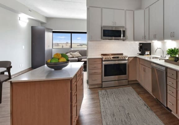 a large kitchen with stainless steel appliances and wooden cabinets