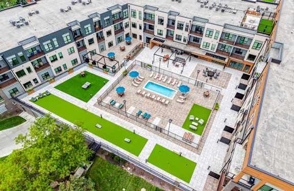 An aerial view of a courtyard with a pool and outdoor yard games.