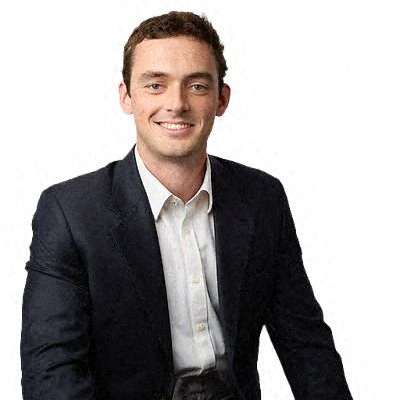 a man in a suit and tie sitting on a chair