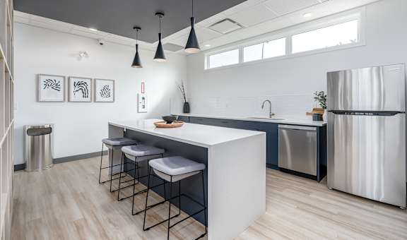 A modern kitchen with a white island and stools.