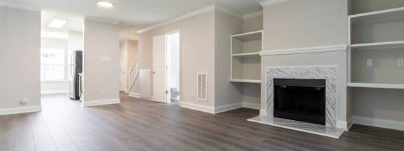 A spacious living room with a fireplace and built-in shelves.