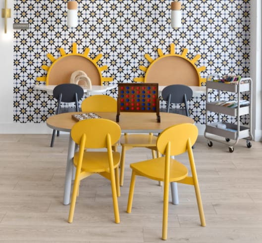 a dining room with a table and yellow chairs and a wall covered in tiles at The Expo, Billings, MT, 59106