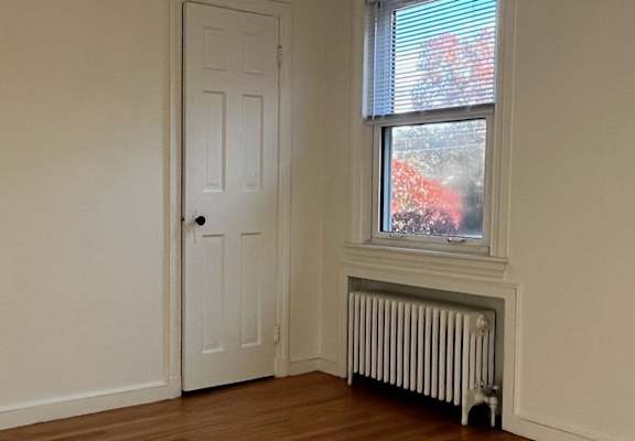 A room with a window and a radiator on the wall.