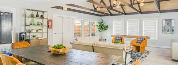 A large table in a room with a shuffleboard table in the background