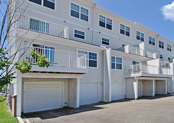 a street view of an apartment building with a car parked in front