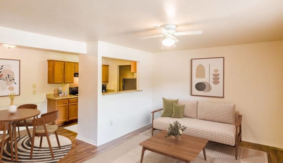 a living room and dining room with a table and a ceiling fan