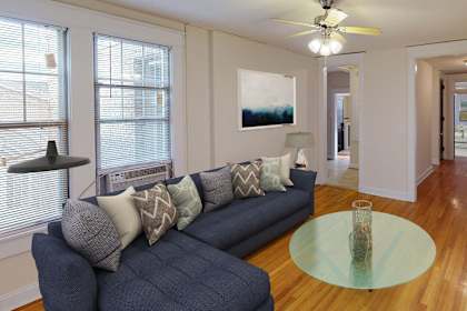 a living room with a blue couch and a glass coffee table