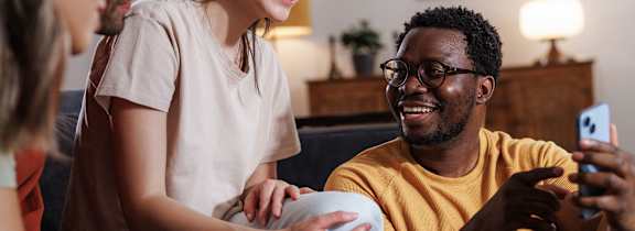 A kitchen with white cabinets and a black refrigerator.