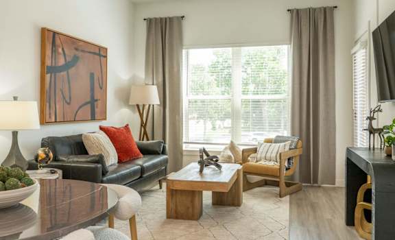 A living room with a couch, coffee table, and a painting on the wall.