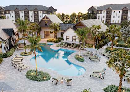 A resort with a swimming pool surrounded by palm trees.