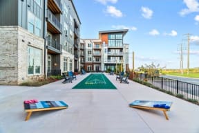 Bocci court and cornhole game sets on the property patio