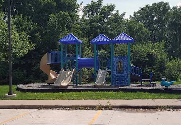 a playground with a slide and swings and a duck
