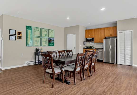 A dining room with a wooden table and chairs.