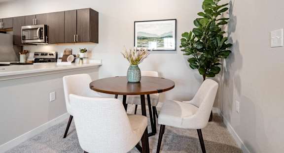 A modern kitchen with a dining table and chairs.