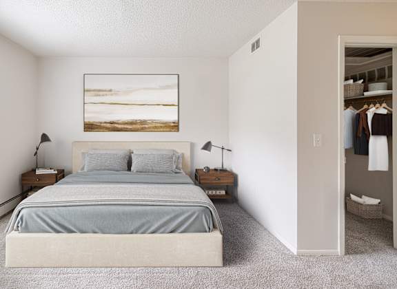 A bedroom with a large bed and a painting on the wall.