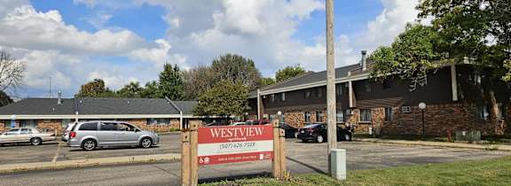 A sign for Westview Apartments stands in front of a grassy area.