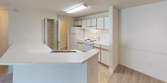 A kitchen with white cabinets and a white counter top.