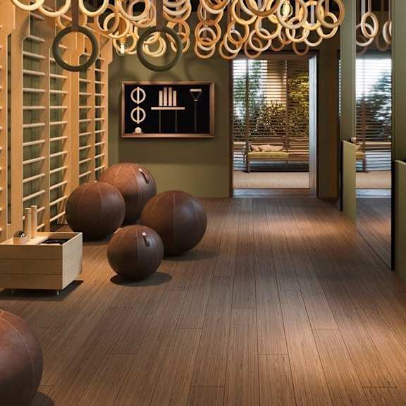 A room with a wooden floor and a wall with a blackboard on it.