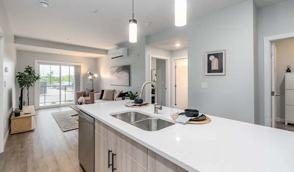 A modern kitchen with a large island and pendant lights.