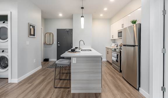 A modern kitchen with stainless steel appliances and a wooden island.