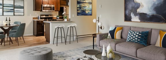 a living room with a couch and a table in front of a kitchen