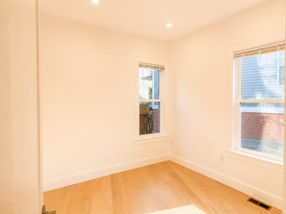 A room with a window and a wooden floor.