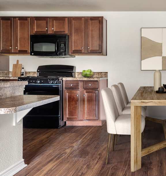 A kitchen with a dining table and chairs.