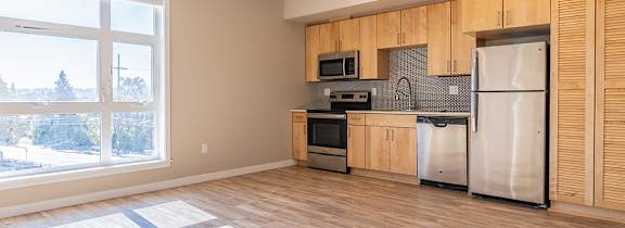 A kitchen with wooden cabinets and a white fridge.