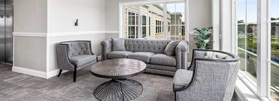 A grey sofa set in a room with a window.