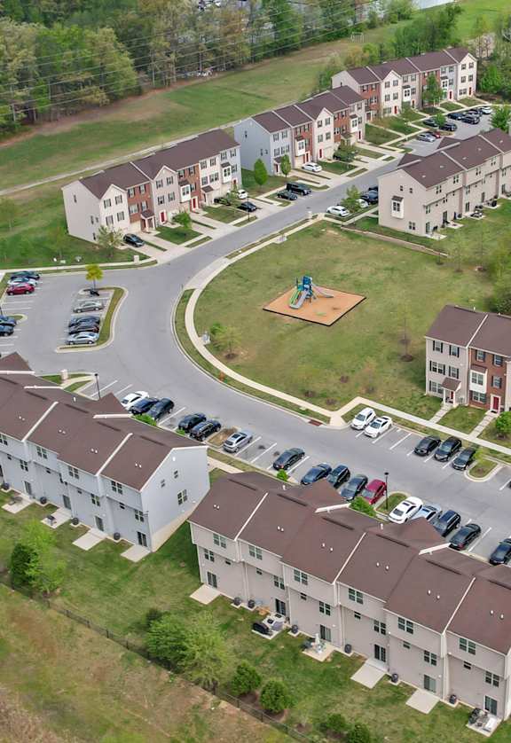A bird's eye view of a residential area with houses and a road.
