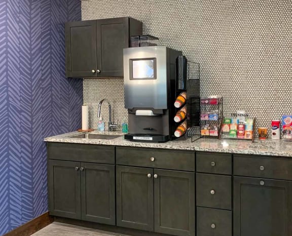 A coffee bar featuring an espresso and latte maker, tea station, and creamers and sugar