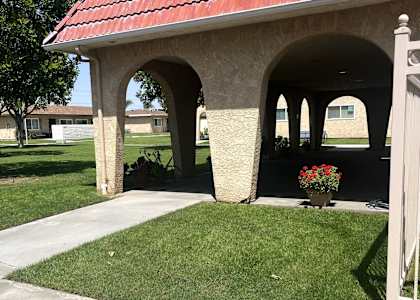 A small building with a red roof and a white fence.