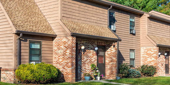 A house with a brown roof and a brick wall.