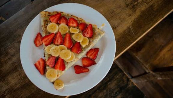 a slice of cake with strawberries and bananas on a plate