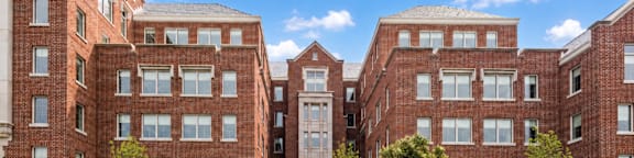 A large red brick building with a tree in front.