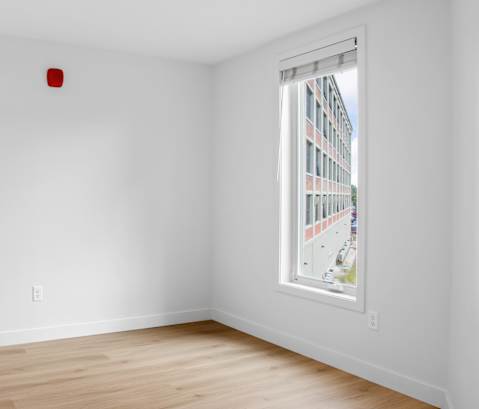 an empty room with white walls and a window